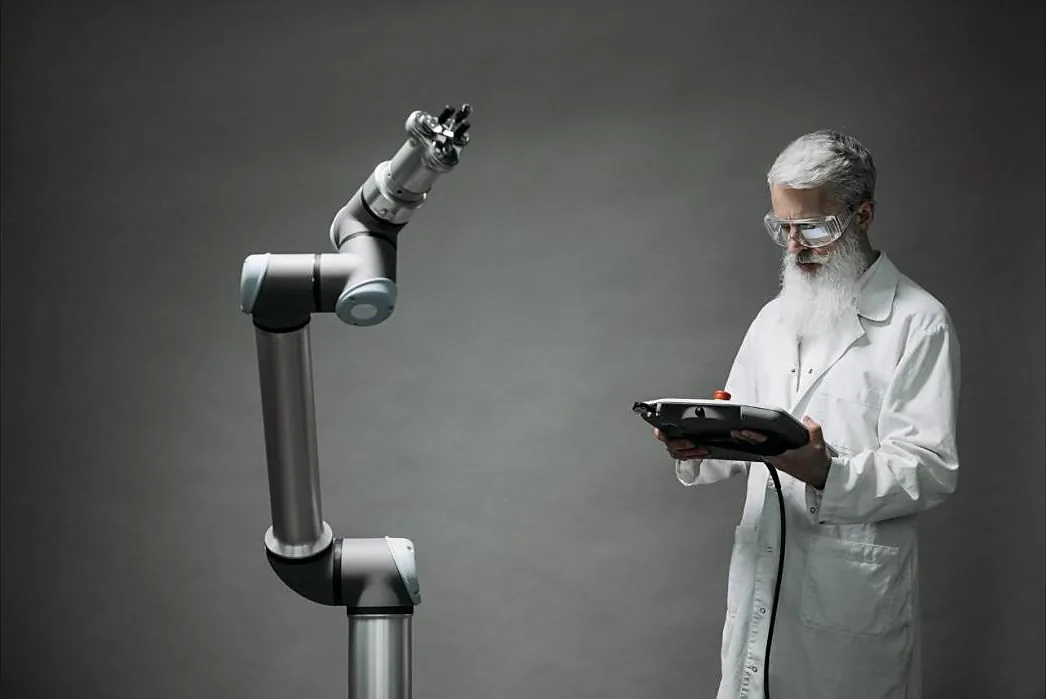 Ingenieur programmiert einen Cobot mit einem Handbediengerät